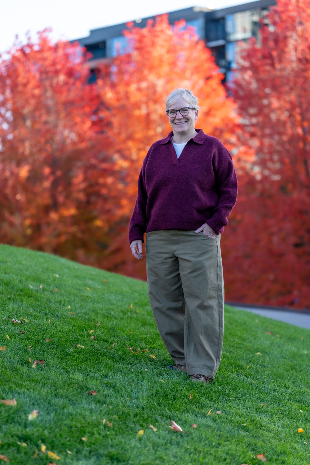 Poppy Potter standing outdoors among red autumn trees
